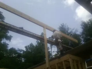Carpenter setting a ridge beam over a new addition frame — Ice Dam Removal by Roofing Brothers in Six Lakes